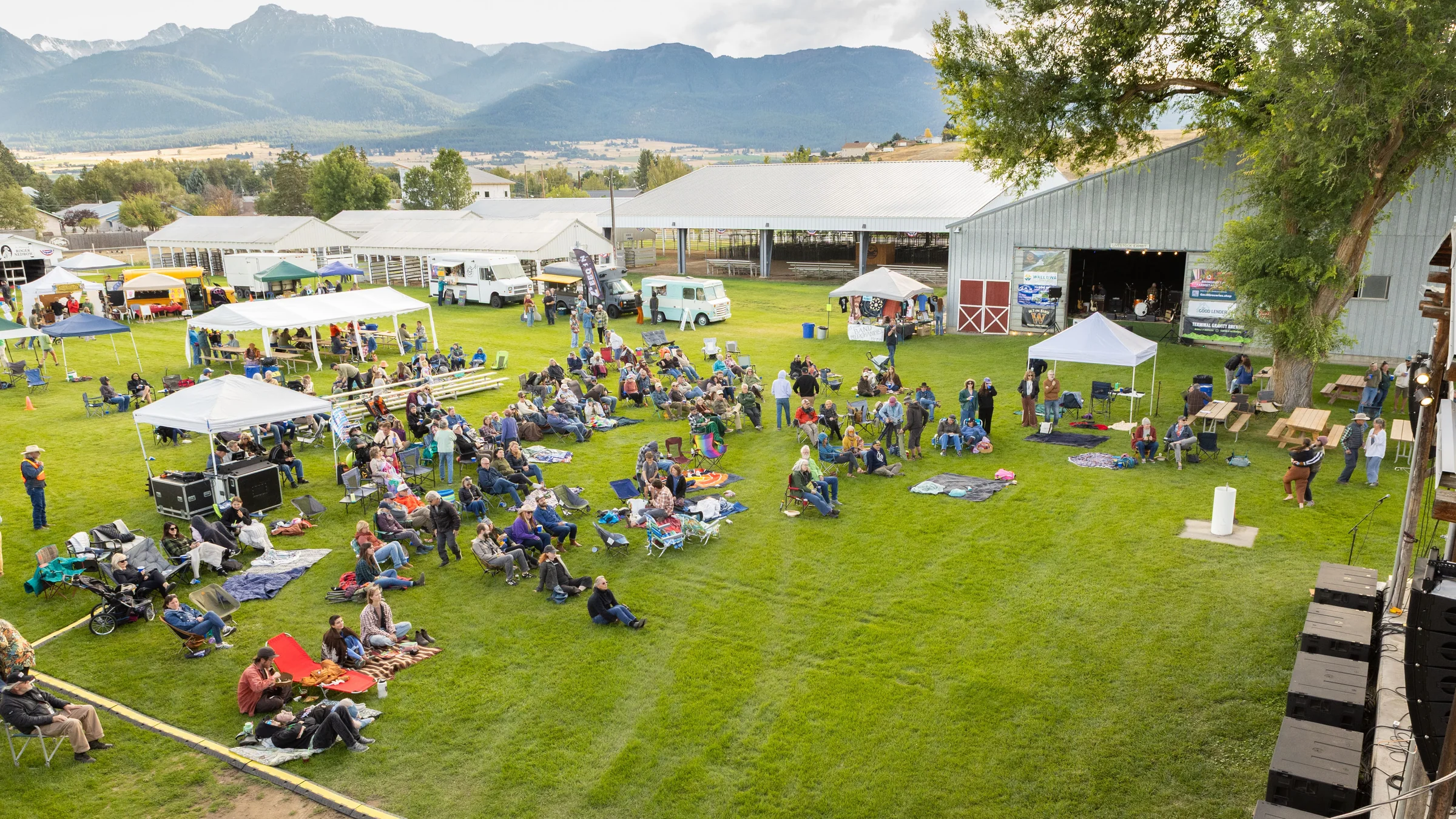 Blankets, tents and the main stage on the lawn at the Wallowa County Fairgrounds, late afternoon at Juniper Jam, September 5, 2026.